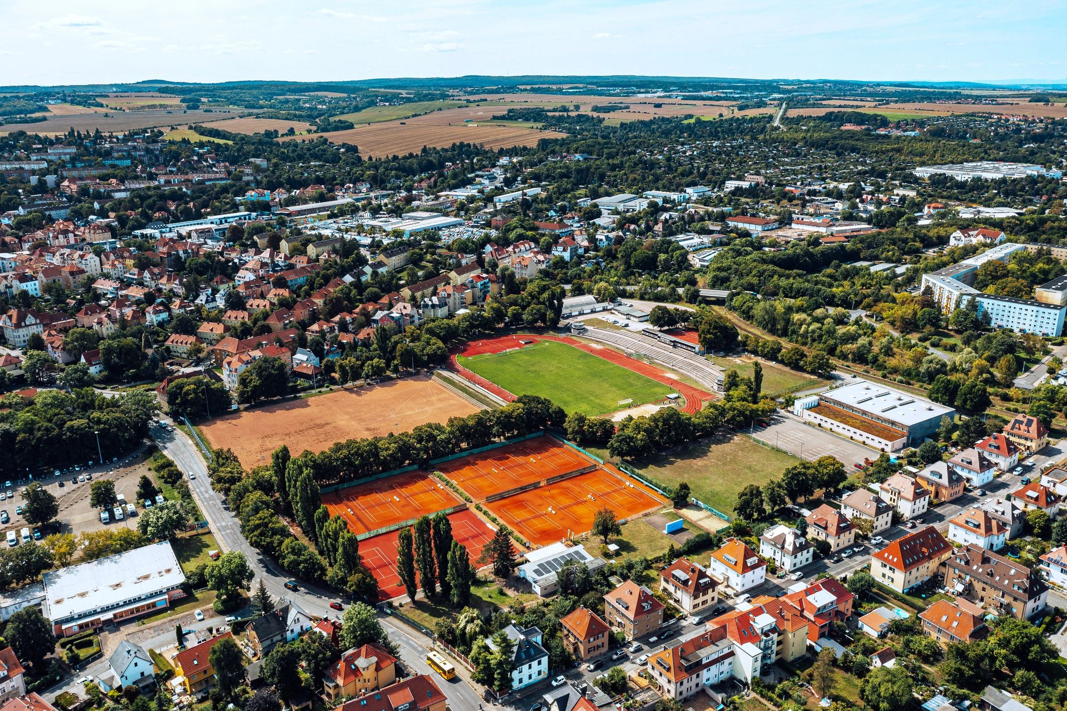 Wide city and sports complex view suggesting football travel destinations