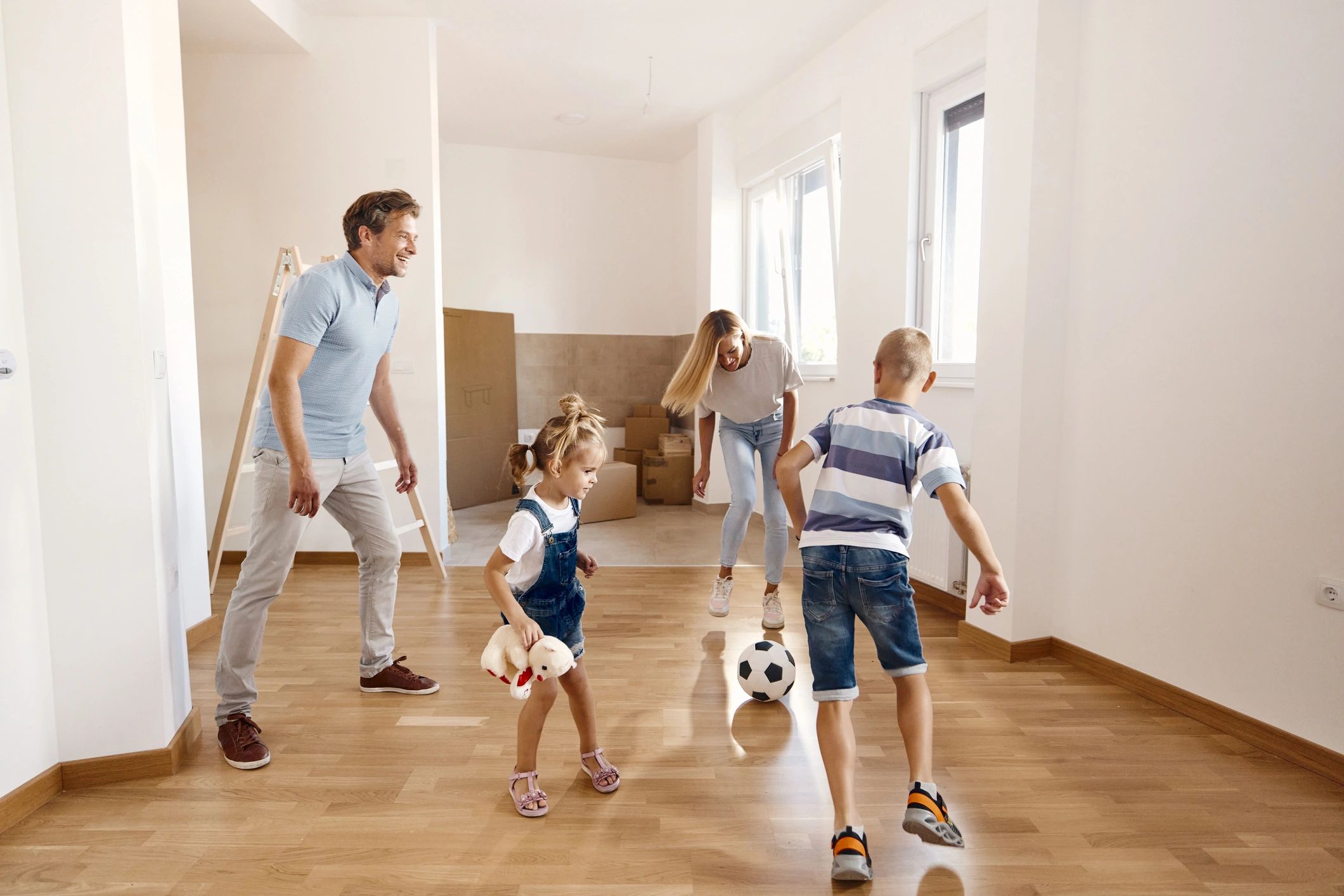 Parents and children playing with a football together