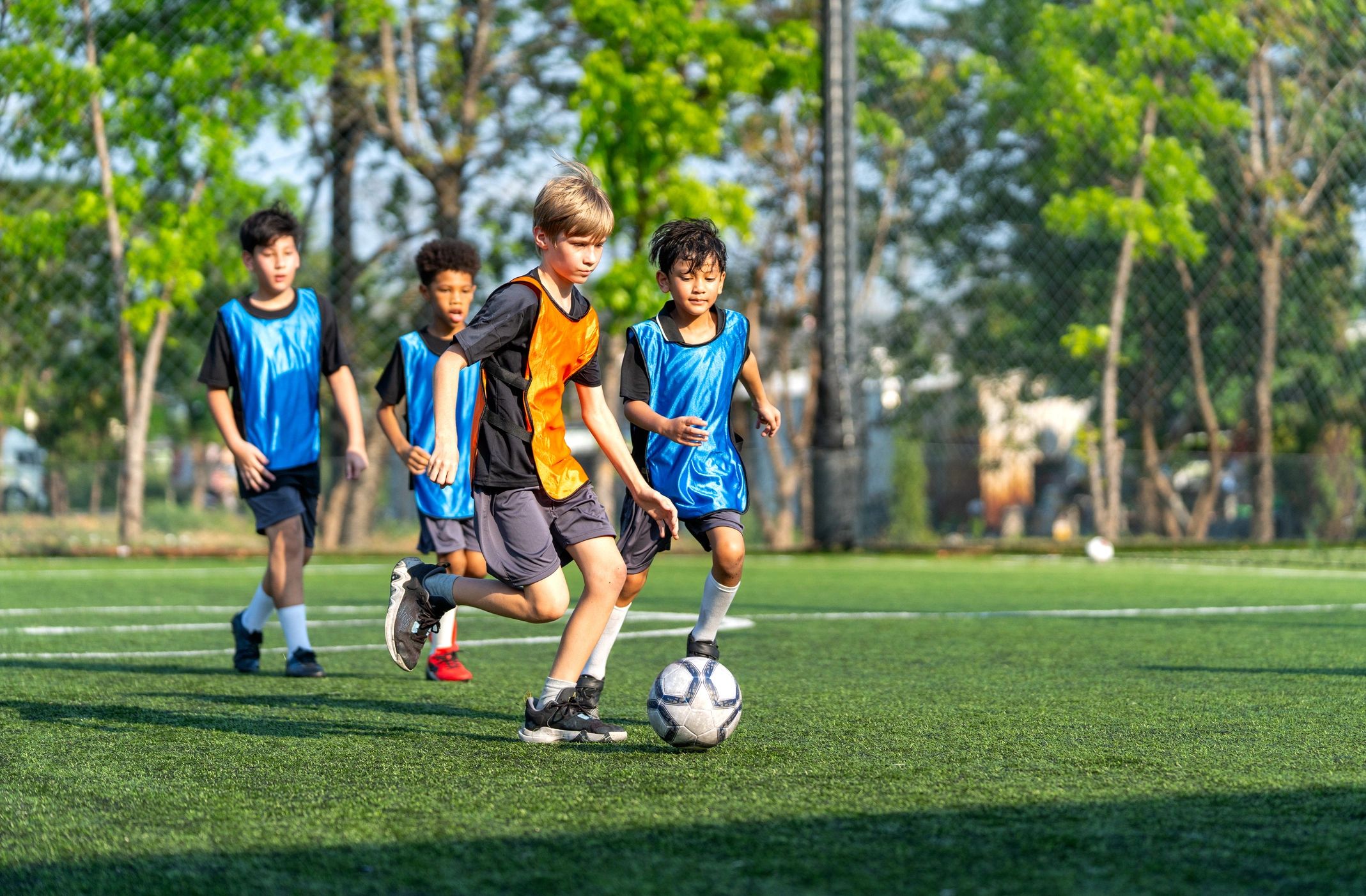 Young footballer playing with friends on the pitch